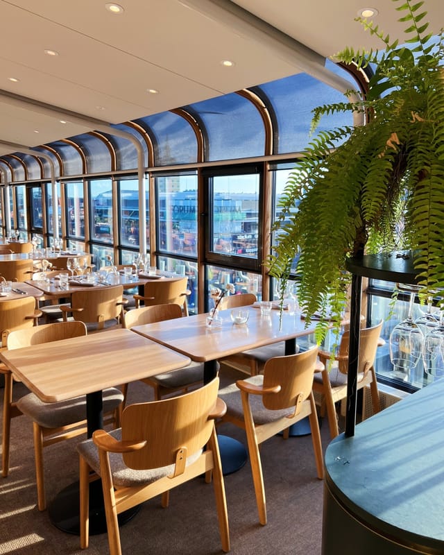 Modern restaurant with large windows, ideal for networking events and workshops.
