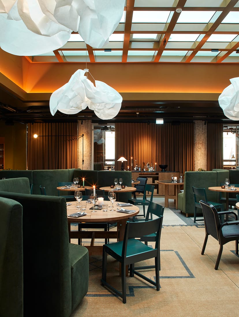 Contemporary restaurant with green upholstery, ideal for corporate events and dinners.
