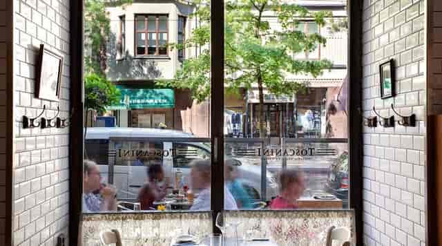Vibrant Restaurant Toscanini café with large windows, ideal for brunch and networking events.