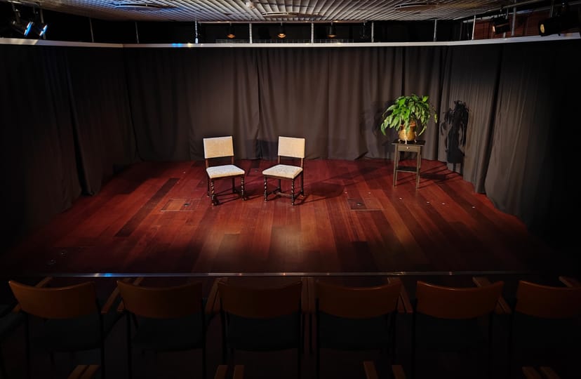 Blackbox theatre stage with empty chairs for intimate panel discussion in NoName Theatre