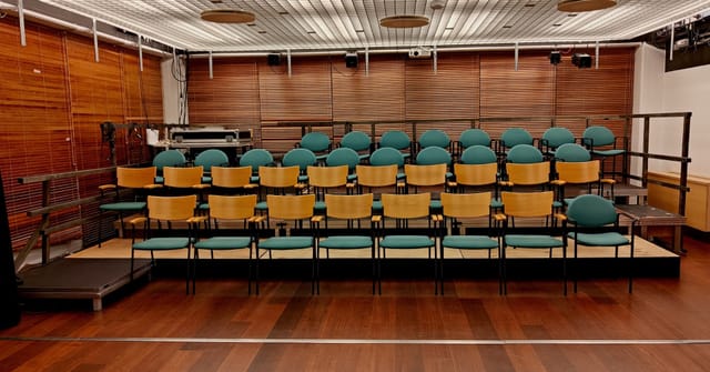 Blackbox theatre seating arrangement for presentations and panel discussions.