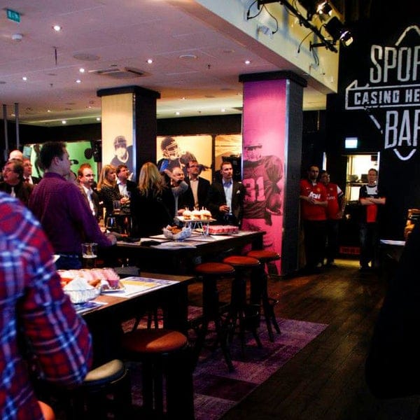 Vibrant networking event at Sports Bar Casino Helsinki with sports-themed decor and professionals.