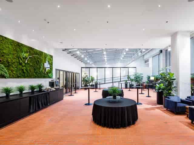 Modern event space in Crowne Plaza Helsinki with stylish round tables and greenery.