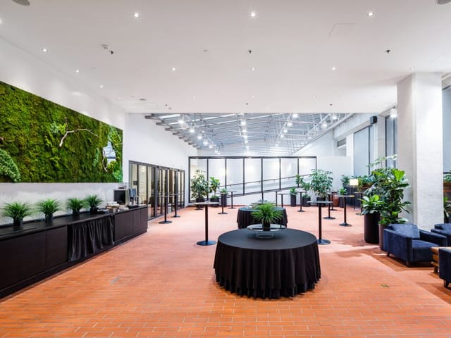 Modern event space in Crowne Plaza Helsinki with stylish round tables and greenery.