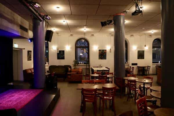 Juhlasali Nostalgia event space with stage and ambient lighting for gatherings and meetings.