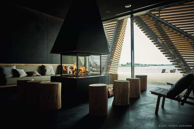 "Modern sauna lounge with central fireplace, ideal for intimate networking events."