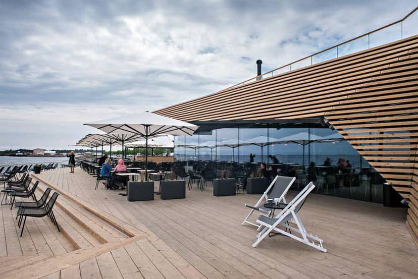 Outdoor event space with wooden decking and waterfront view, perfect for receptions and meetings.