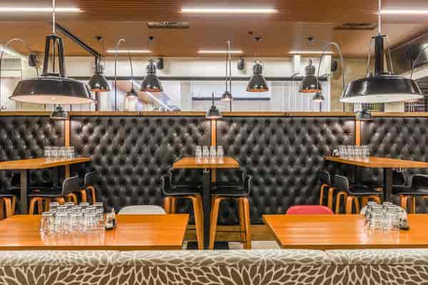 Modern dining space in Ravintola Domus with tufted seating for events.