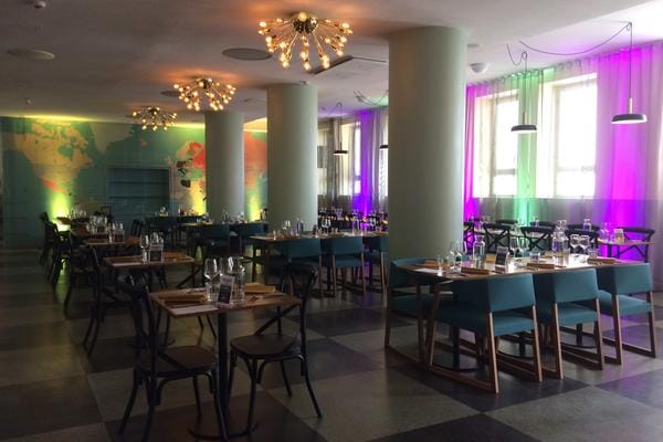 Modern event space in Ravintolasali, featuring stylish lighting and a world map backdrop.