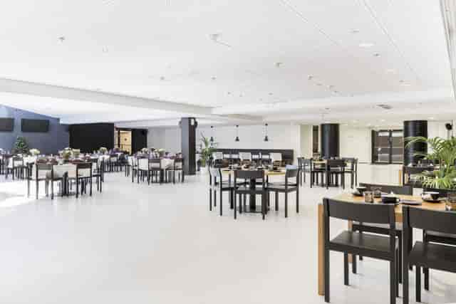 Spacious modern meeting venue with elegant dining setup for events in Ravintolasali.
