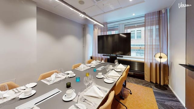 Modern meeting room at Tapahtumatalo Bank with sleek table setup for corporate events.