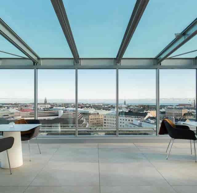 Modern glass-enclosed Sky Lounge with city skyline views, perfect for corporate events.