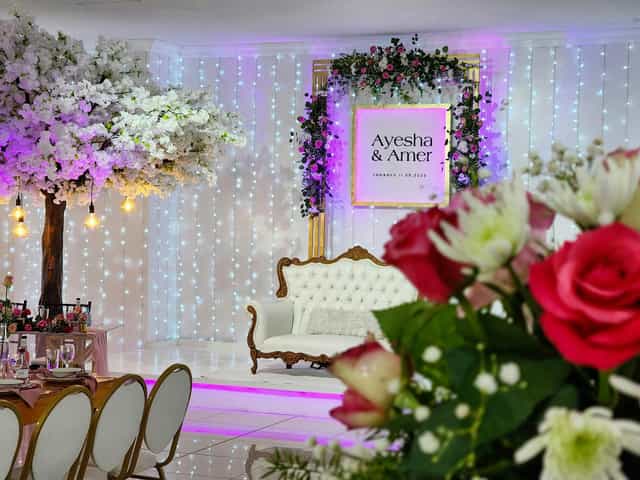 Elegant outdoor wedding venue with floral decor and vintage couch for celebrations.