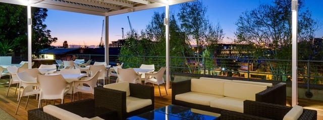 Breakwater Lodge rooftop event space, modern furnishings, ideal for networking and sunset gatherings.