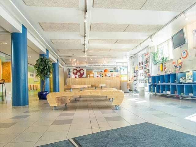 Modern Eurohostel lounge with wooden seating, perfect for workshops and community events.