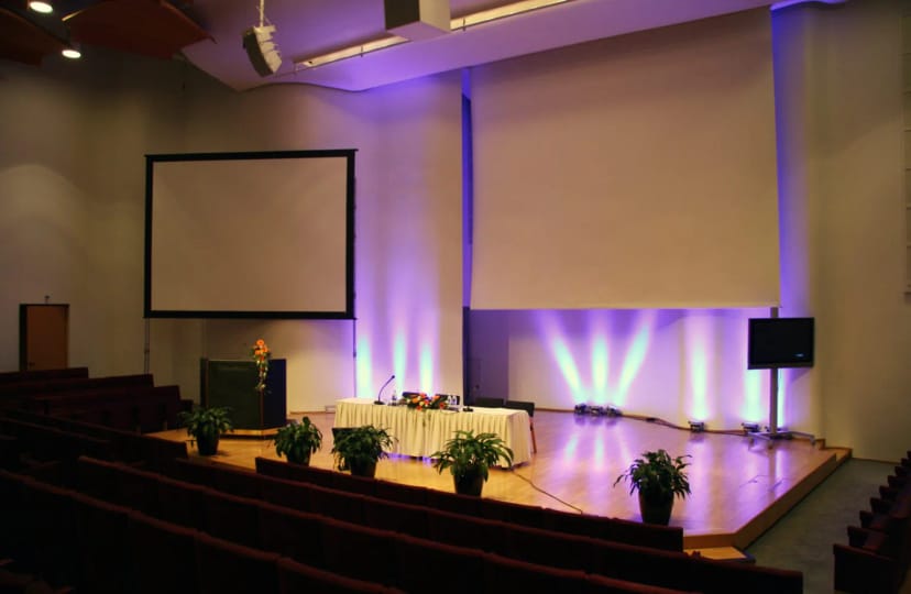 Annantalo auditorium with staged speaker area for professional conferences and presentations.