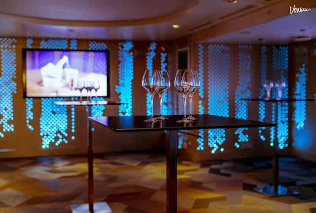 Stylish event space at Klaus K Hotel with modern tables and blue ambiance for networking receptions.