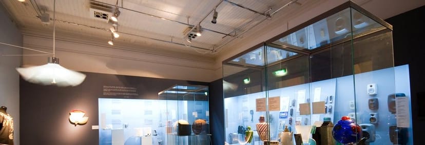 Modern design museum exhibition space with glass display cases for events.