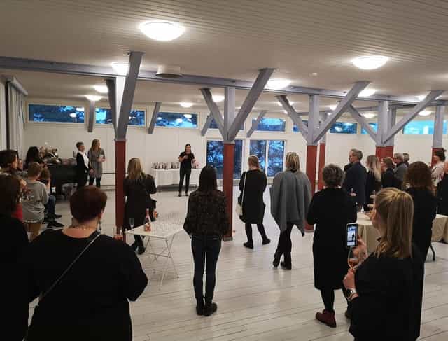 Lively networking event in Hietsun Paviljonki with engaging speaker and natural light.