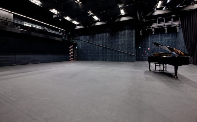 Versatile performance space in Musiikkitalo with grand piano for concerts and events.