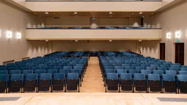 Kookos Auditorium 2 in Uniarts Helsinki with blue chairs, ideal for conferences and presentations.