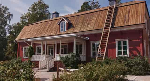 Red rustic Parsonage at Seurasaari Museum, ideal for outdoor events and gatherings.