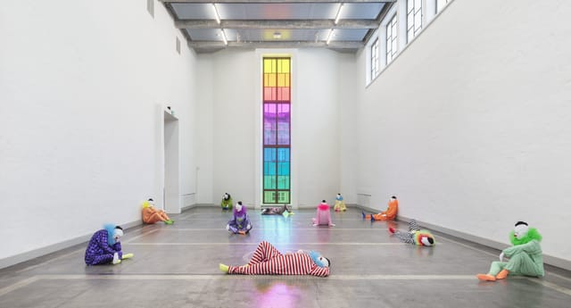 Spacious Kunsthalle Helsinki gallery with colorful figures and stained glass for creative events.