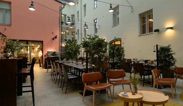 Stylish event space with greenery, perfect for meetings and receptions at Ravintola Olo.
