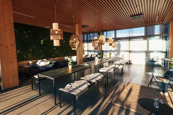 Häät at Ravintola Nokka: modern event space with natural wood and greenery, ideal for gatherings.