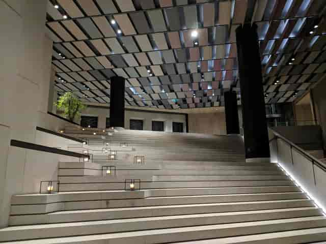 Modern white foyer with elegant stone stairs, ideal for high-end events and receptions.