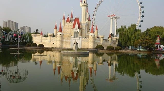 "Whimsical castle by pond at Shijingshan Amusement Park, perfect for events and weddings."