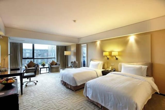 "Modern hotel suite with two beds, ideal for business travel and meetings."