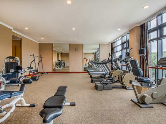Well-lit Holiday Inn gym with cardio machines, ideal for corporate wellness retreats.