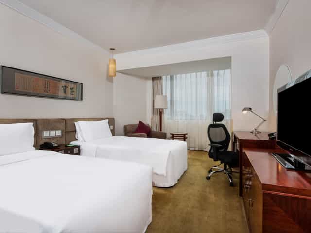 Holiday Inn Beijing suite with two beds for event attendees, ideal for comfort and productivity.