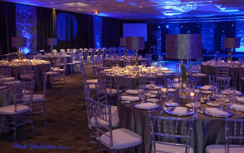Sophisticated event setup with elegant tables and blue lighting at Carmen's Event Centre.