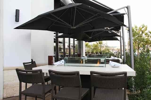 Semi-private outdoor dining at Il Fornaio with modern furniture for events