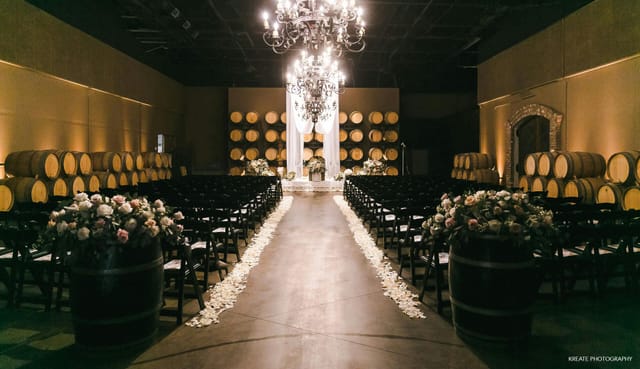 Palm Event Center Estate Room with chandelier, rustic wine barrels for elegant weddings.