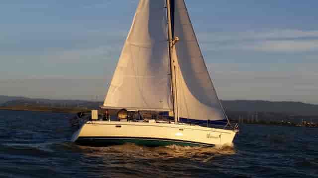 Sailboat gliding in calm waters at Coyote Point Yacht Club for corporate retreats.