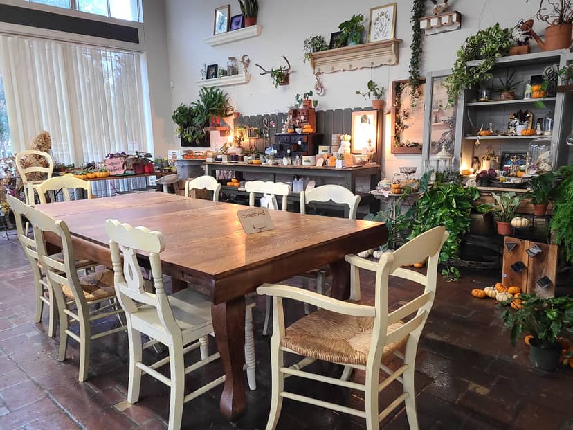 "Cozy meeting space at Little Green A Plant Bar with wooden table, perfect for workshops."