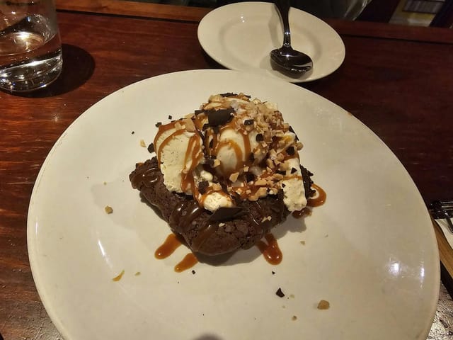 Warm brownie dessert with vanilla ice cream, ideal for events and celebrations in San Carlos.