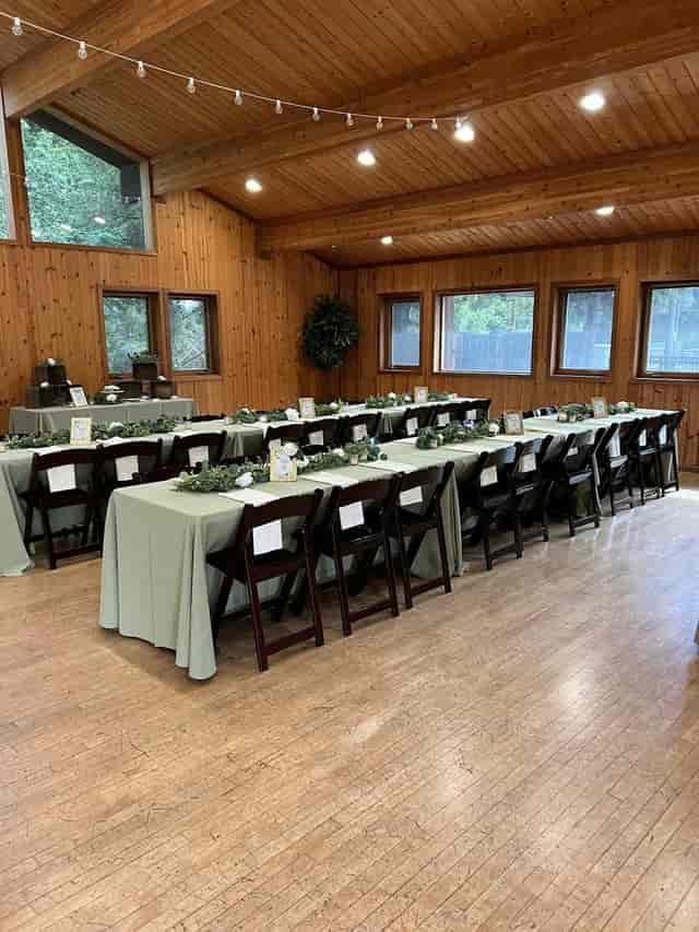 Event space with long tables, green tablecloths, ideal for gatherings and celebrations
