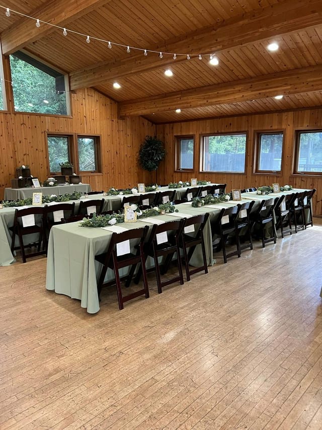 Event space with long tables, green tablecloths, ideal for gatherings and celebrations