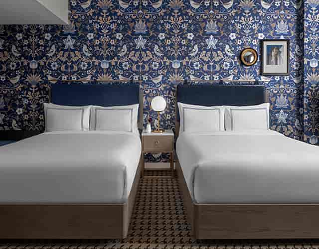 Elegant hotel room with two beds, perfect for conference attendees and events.