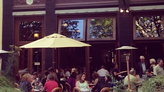 Vesta Redwood City outdoor dining with umbrellas, perfect for casual networking events.
