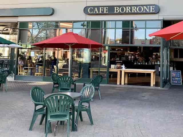 Outdoor café with red umbrellas, perfect for casual meetings and networking events.
