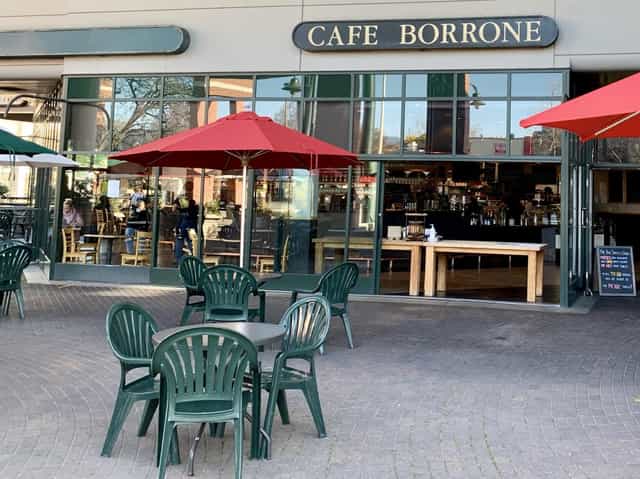 Outdoor café with red umbrellas, perfect for casual meetings and networking events.