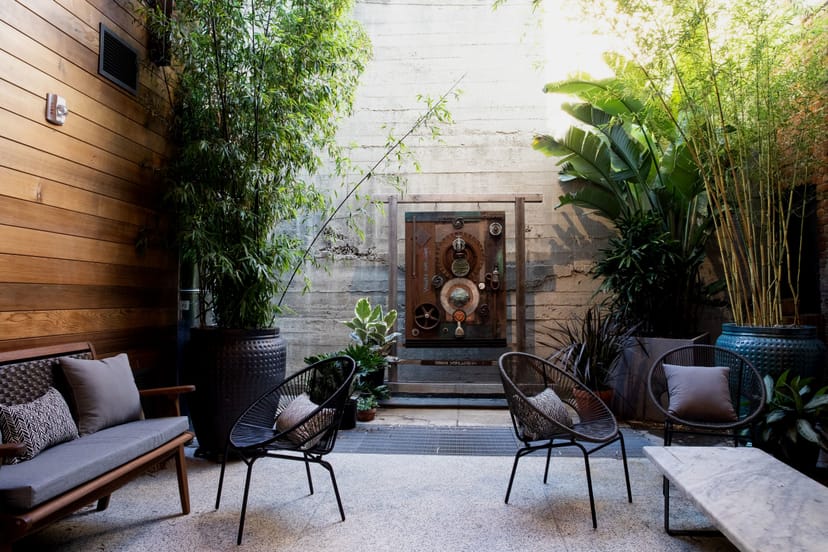 "Stylish outdoor patio with greenery for intimate gatherings and networking events."