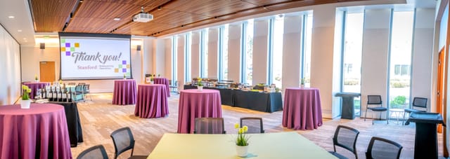 Cardinal Hall event space with purple tables for networking and presentations in Stanford.
