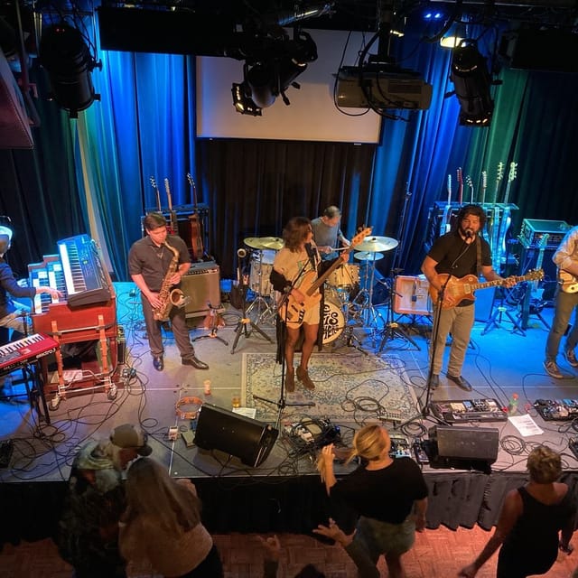 Vibrant live band performance with colorful lighting at a music venue in Redwood City.