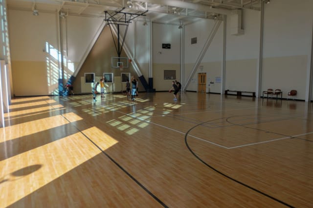 Spacious gym with polished floors for Open Gym Basketball events at Peninsula Community Center.